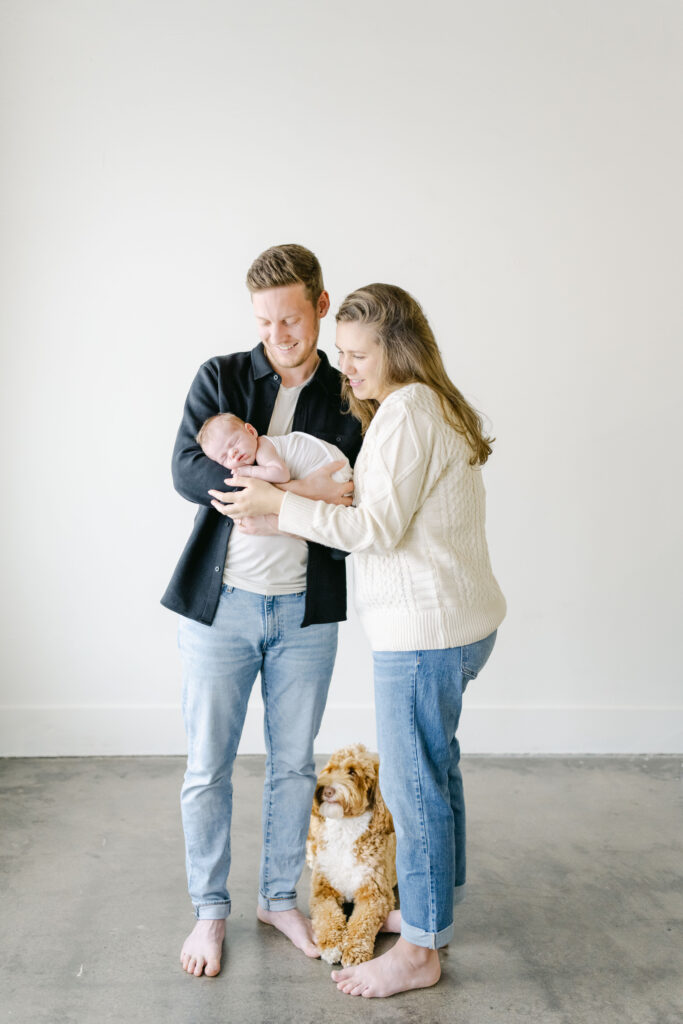 Parents lovingly looking down at their newborn baby during a natural newborn photography session